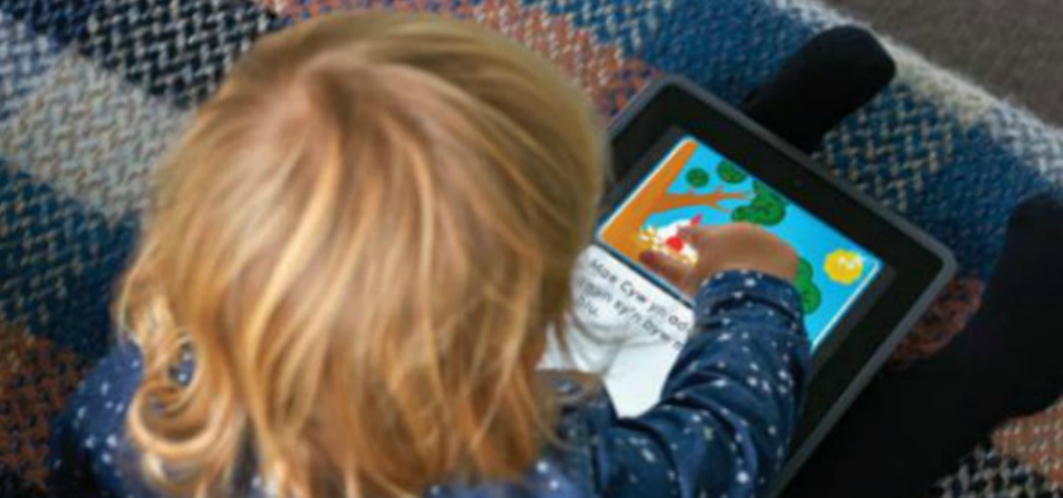 A toddler playing on an ipad