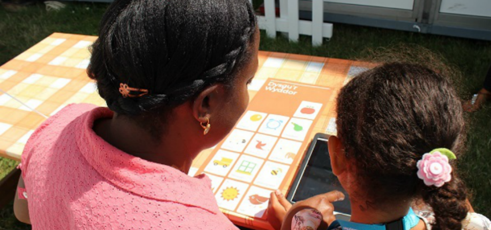 A mother with her daughter reading from an ipad