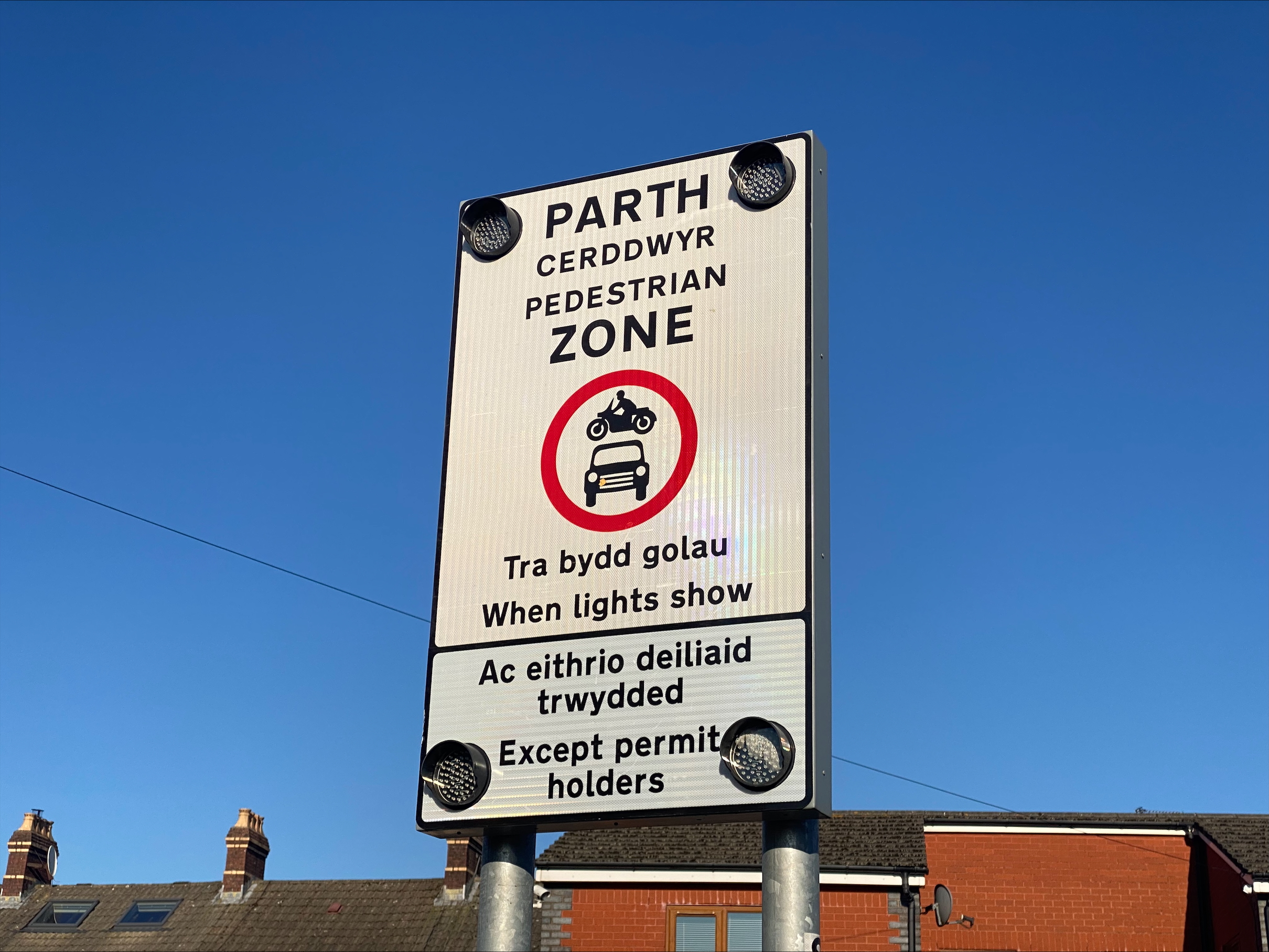 Photograph showing school street road sign, making clear that motor vehicles are not allowed while lights are showing, except permit holders.