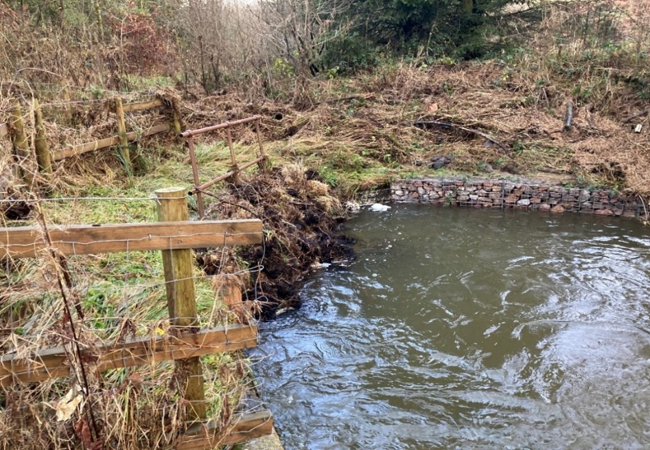 A culvert grille on a disused tip blocked by storm debris