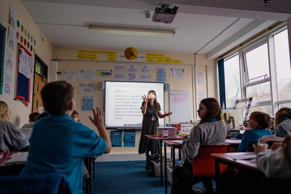 Welsh language teacher in front of classroom of learners.