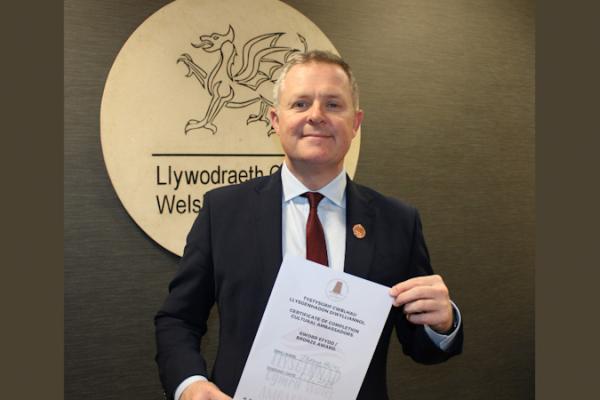 Jeremy Miles, the Minister for Education and Welsh Language, with certificate.