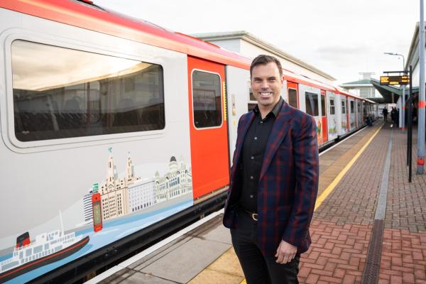Cabinet Secretary for Transport and North Wales Ken Skates and a newly wrapped train on the renamed Wrexham to Liverpool line