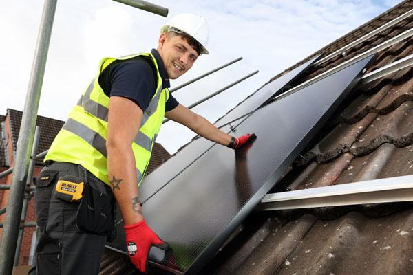 Man installing solar panel on roof.