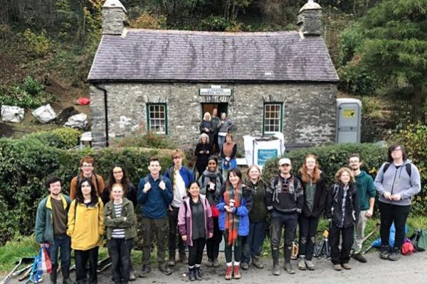 Group photo: Members and volunteers of Llanafan Women’s Institute standing outside the WI Cottage in Llanafan, Ceredigion.