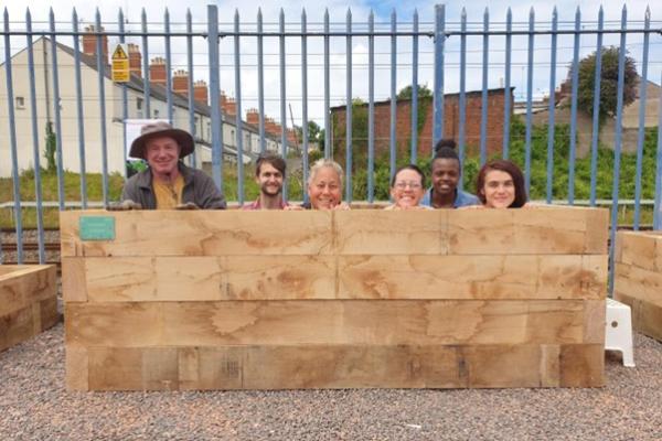 Railway Gardens volunteers of all ages building raised beds and planting in the community hub, Splott, Cardiff.